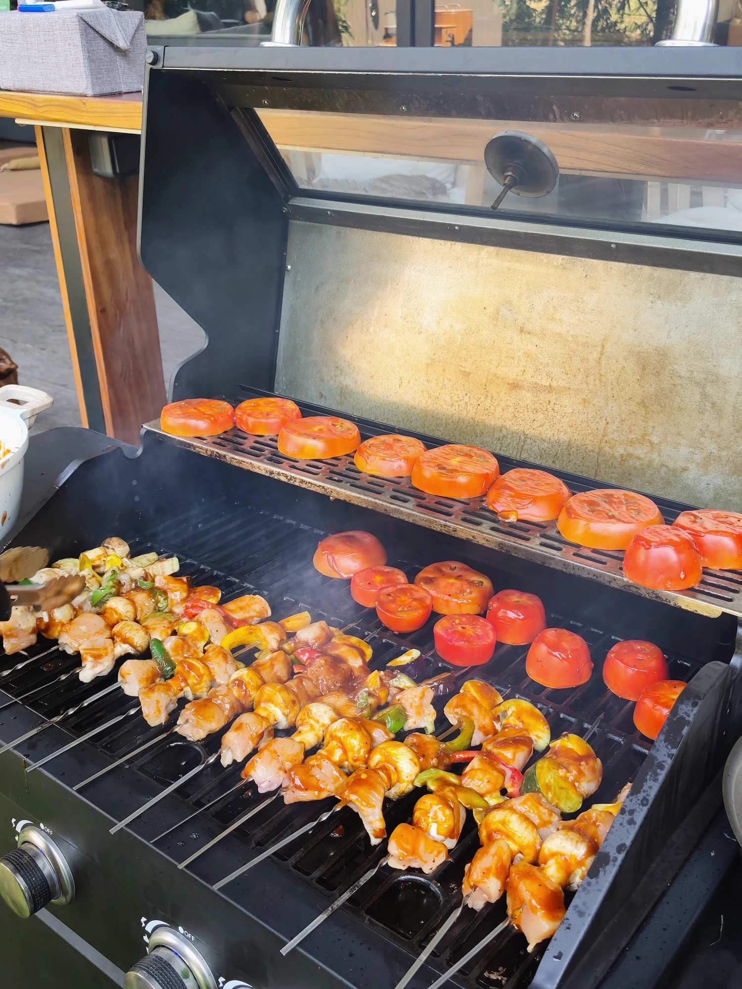 Skewers and tomatoes cooking on a barbecue