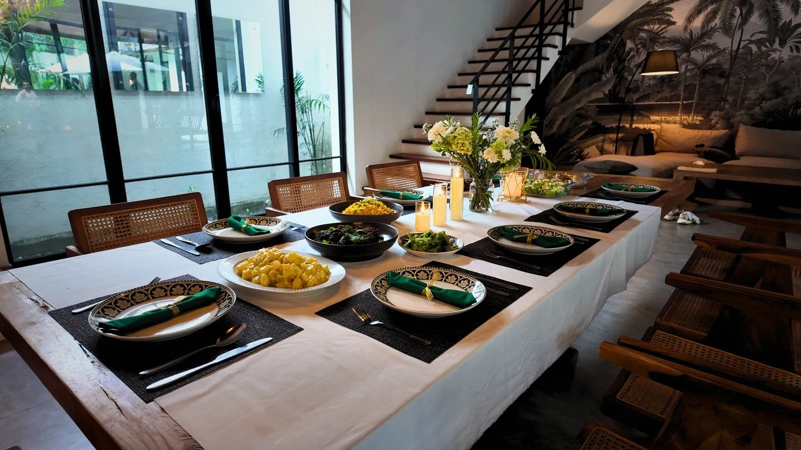 A villa dining table set with plates of food beside the garden