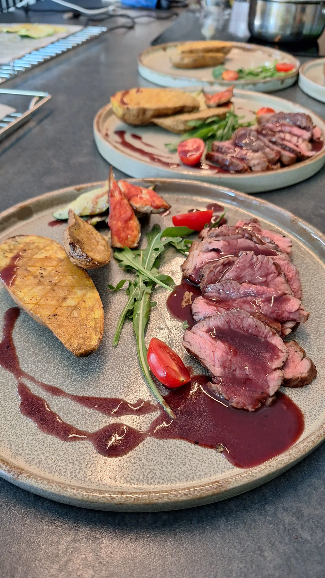 Sliced beef with vegetables and sauce on plates ready for service