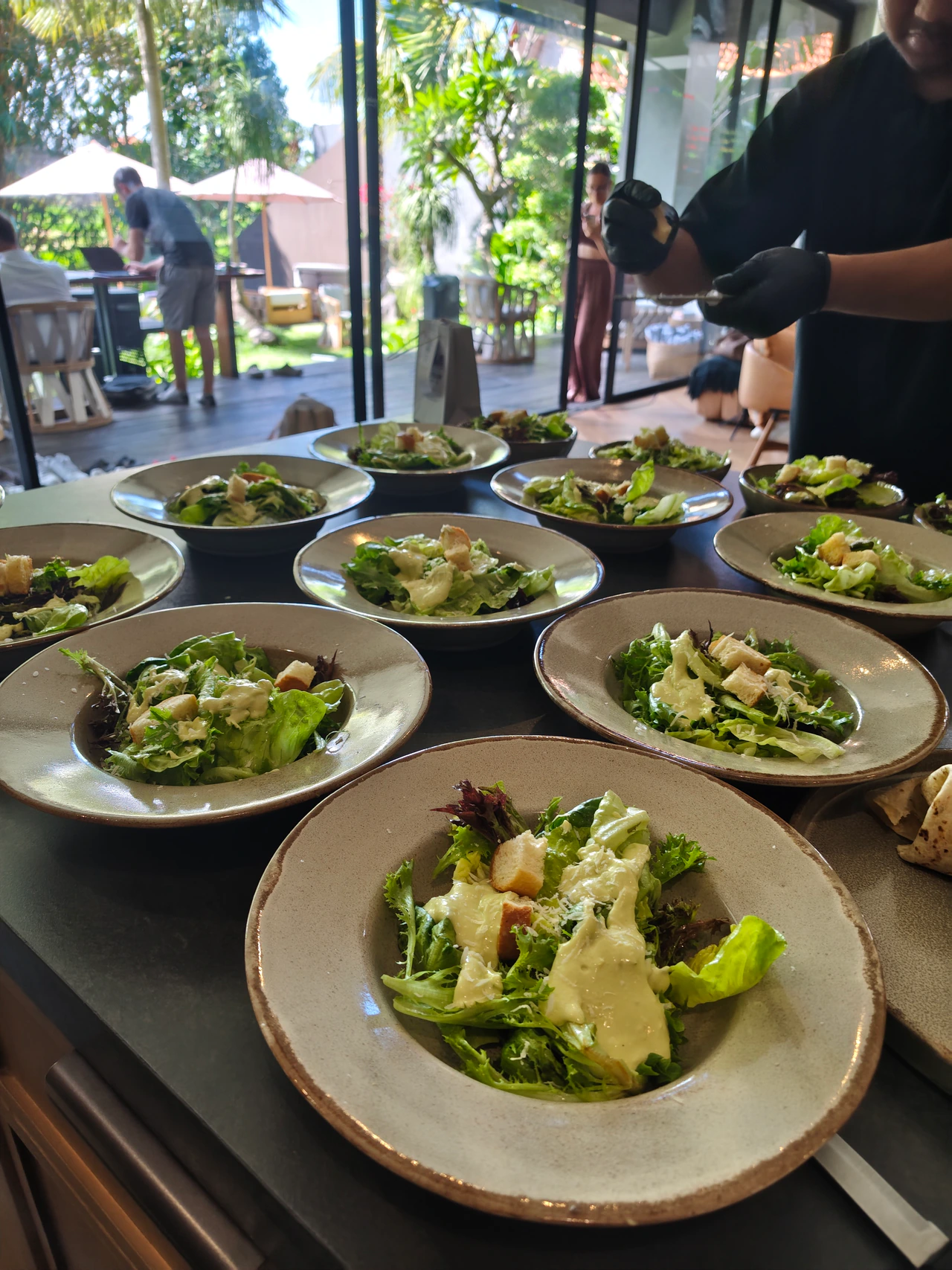 A chef finishing plates beside a villa dining table