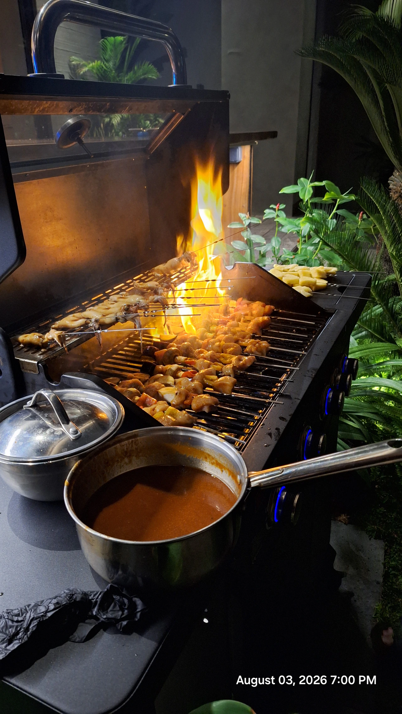 Food cooking on a grill with flames rising above it